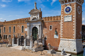 A photo of a clock tower in a brick building with a statue of a lion