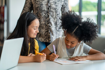 Young school students are having fun in the class by helping each other study the class assignment...