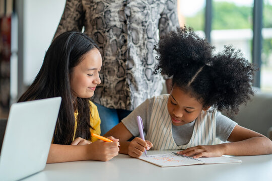 Young school students are having fun in the class by helping each other study the class assignment and onlin information from internet for academic literacy and education usage - Powered by Adobe