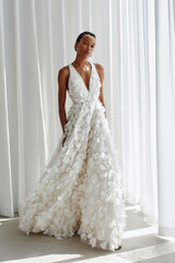 Fototapeta premium A couture bridal gown adorned with hand-embroidered floral petals, delicate botanical motifs, and rich organic textures. The design celebrates feminine strength soft but powerful,