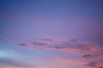 A beautiful evening sky painted in soft pastel colors of pink, purple, and orange. Wispy clouds...