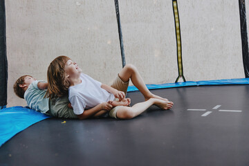 Joyful children playing on a trampoline, expressing happiness and excitement while enjoying their...