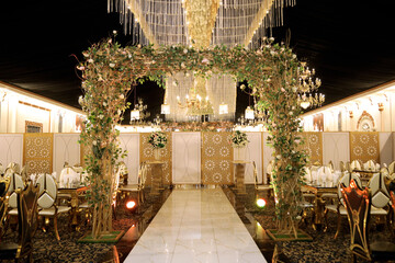 Elegant Wedding Entrance Arch Decorated with Flowers and Lights