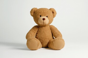 Obraz premium Soft and Cuddly Plush Teddy Bear Sitting on White Background, Ideal for Nursery Decor, Children's Gifts, and Playtime Companions for All Ages