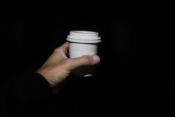 Takeaway cup held outdoors in soft light, great for travel, break, or coffee promotions.
