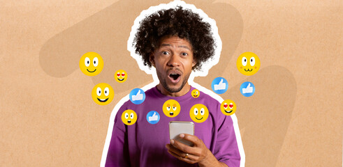 Shocked African American guy with curly hair using smartphone, engaging in messaging. Colorful emojis float around them, indicating interaction and excitement about social media.