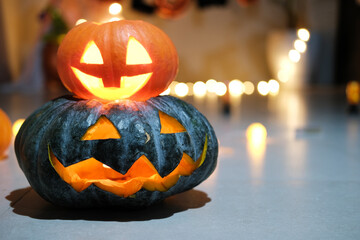 In a dark room, the symbol of Halloween is a pumpkin head with a candle inside. Decorations for a...