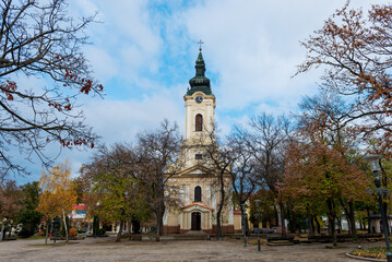 The Monastery of the Holy Trinity in Kikinda rises behind leafless autumn trees. Its baroque bell...