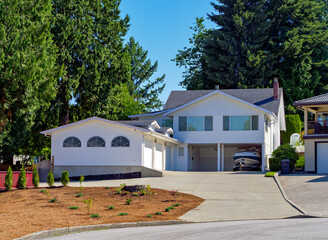 Suburban family house with small boat on trailer parked under carport
