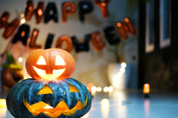 In a dark room, the symbol of Halloween is a pumpkin head with a candle inside. Decorations for a...
