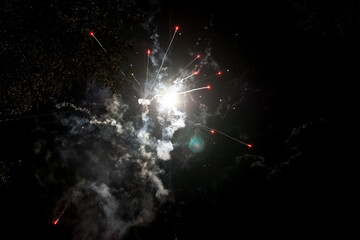 Vibrant fireworks display lighting up the night sky during a festive celebration in a suburban...