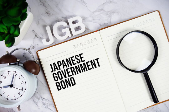 JGB - Japanese Government Bond acronym on notepad, Business concept background