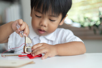A young boy is playing with a toy boat that has a propeller
