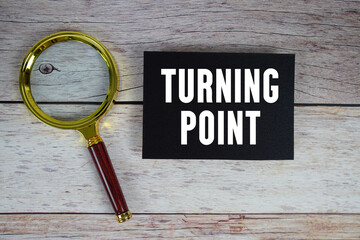 Turning Point text written on paper with magnifying glass