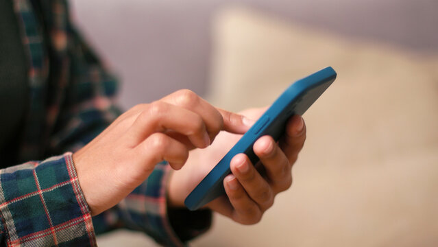 Latin American woman texts tapping smartphone screen