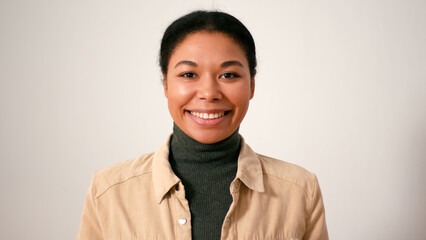 Pretty Hispanic woman wearing casual outfit smiles in studio