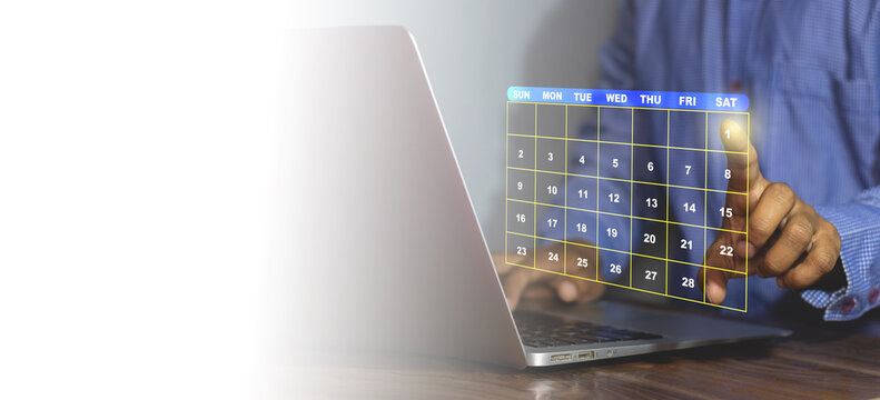 Businessman scheduling a digital calendar on laptop, highlighting the first date of the month, symbolizing time management, appointment booking, event planning, productivity