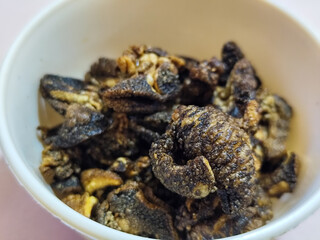 Flourless snail chips have a savory, delicious and crunchy taste. Presented with a white bowl with a natural blur background.