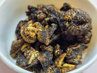 Flourless snail chips have a savory, delicious and crunchy taste. Presented with a white bowl with a natural blur background.