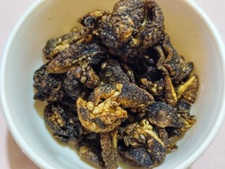Flourless snail chips have a savory, delicious and crunchy taste. Presented with a white bowl with a natural blur background.