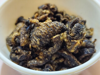 Flourless snail chips have a savory, delicious and crunchy taste. Presented with a white bowl with a natural blur background.