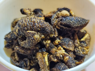 Flourless snail chips have a savory, delicious and crunchy taste. Presented with a white bowl with a natural blur background.