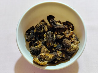 Flourless snail chips have a savory, delicious and crunchy taste. Presented with a white bowl with a natural blur background.