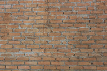 Rustic Brick Wall. Traditional orange brick wall with mortar, showcasing the rough texture and imperfect alignment.