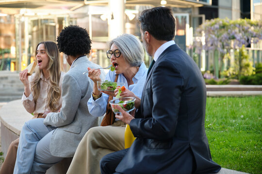 Multi ethnic business team enjoying a healthy lunch break together outdoors