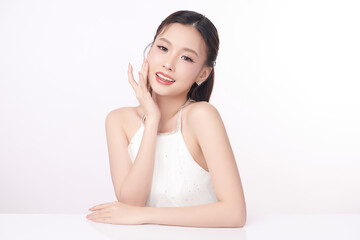 A beautiful young Asian woman with clean, fresh skin against a white background. Skincare, facial...