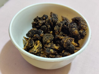 Flourless snail chips have a savory, delicious and crunchy taste. Presented with a white bowl with a natural blur background.