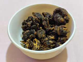 Flourless snail chips have a savory, delicious and crunchy taste. Presented with a white bowl with a natural blur background.