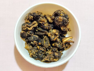 Flourless snail chips have a savory, delicious and crunchy taste. Presented with a white bowl with a natural blur background.