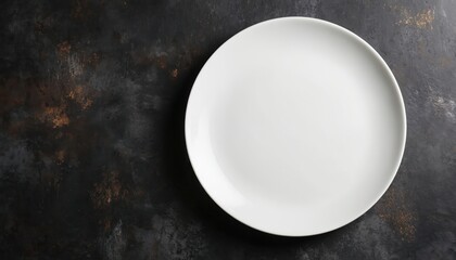White plate positioned on black countertop. Dark gray background creates stark contrast. Empty, smooth, round plate surface suggests pause or anticipation. Simple, modern kitchen setting.