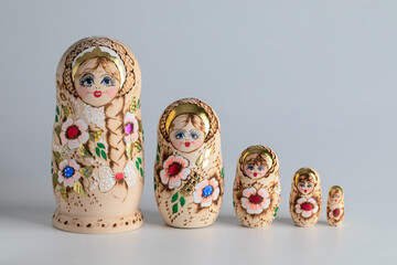 Disassembled matryoshka dolls displayed in a row by height on a light background