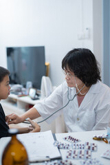  A pediatrician uses a stethoscope during a health examination at the clinic.