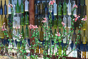 Close-up of colorful glass bottles arranged vertically as an artistic outdoor installation in...