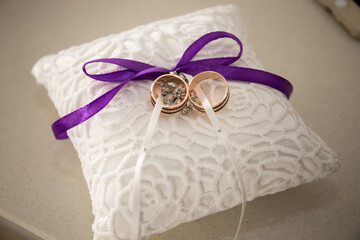 Delicate wedding ring pillow adorned with purple ribbon, symbolizing love and commitment at a...