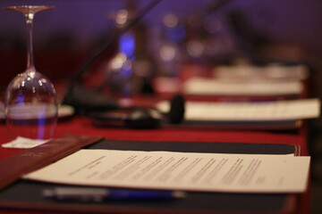 Elegant setup for a business meeting with documents, glasses, and technology on a polished table in a conference room