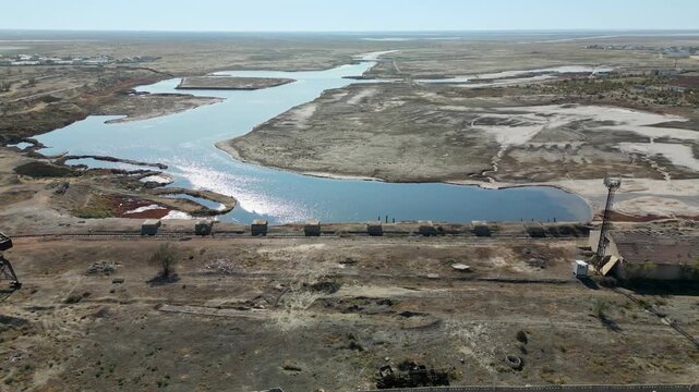 Aerial view of Aralsk&rsquo;s former port. Rusted cranes and old rail tracks are near the dried seabed and a narrow canal &mdash; the remnants of a once-bustling fishing hub.
Aral sea seen on the horizon