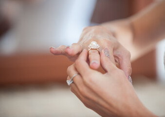 Elegant hands delicately placing a pearl ring at a sunlit wedding venue in the afternoon