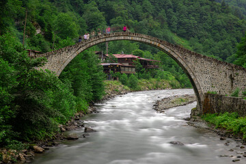 The historic stone bridge and green nature scenery of Senyuva village in Rize province.