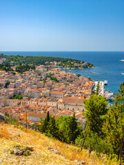 Panoramic view of Hvar, Croatia from a hilltop with red-tiled roofs, marina, yachts, Adriatic Sea,...