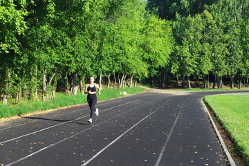 Adult European Woman in Black Running in Open Stadium.