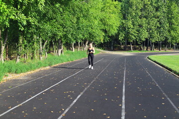 Adult European Woman in Black Running in Open Stadium.