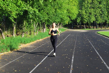 Adult European Woman in Black Running in Open Stadium.