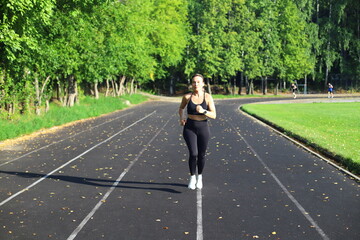 Adult European Woman in Black Running in Open Stadium.
