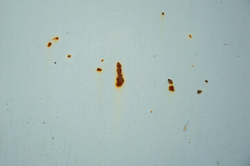 Rust stains are visible on a white surface, showcasing deterioration due to oxidation in an...