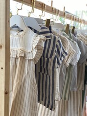 Childrens clothing on hangers with striped designs in natural tones