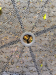 A weather-resistant, textured background for a small cafe table in a public park, made of iron. Durable, comfortable, and ideal for outdoor public spaces, parks, sidewalks, or recreational areas.